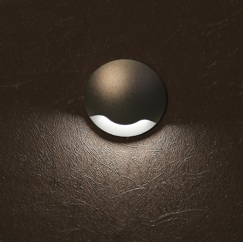 Recessed anti-glare step light casting a low pool of warm light across a stair tread