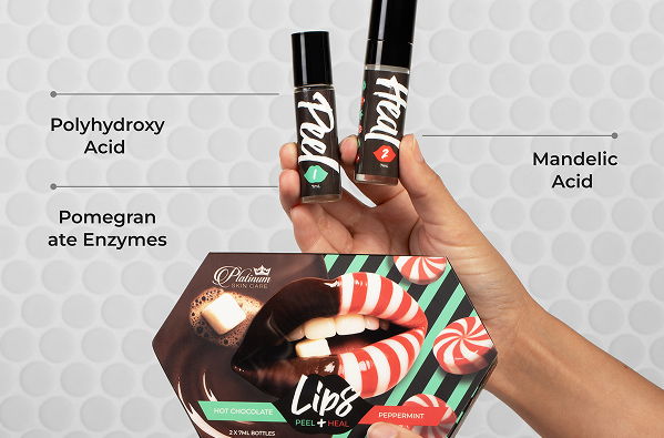 Hand holding two lip products and a colorful package with ingredient labels.