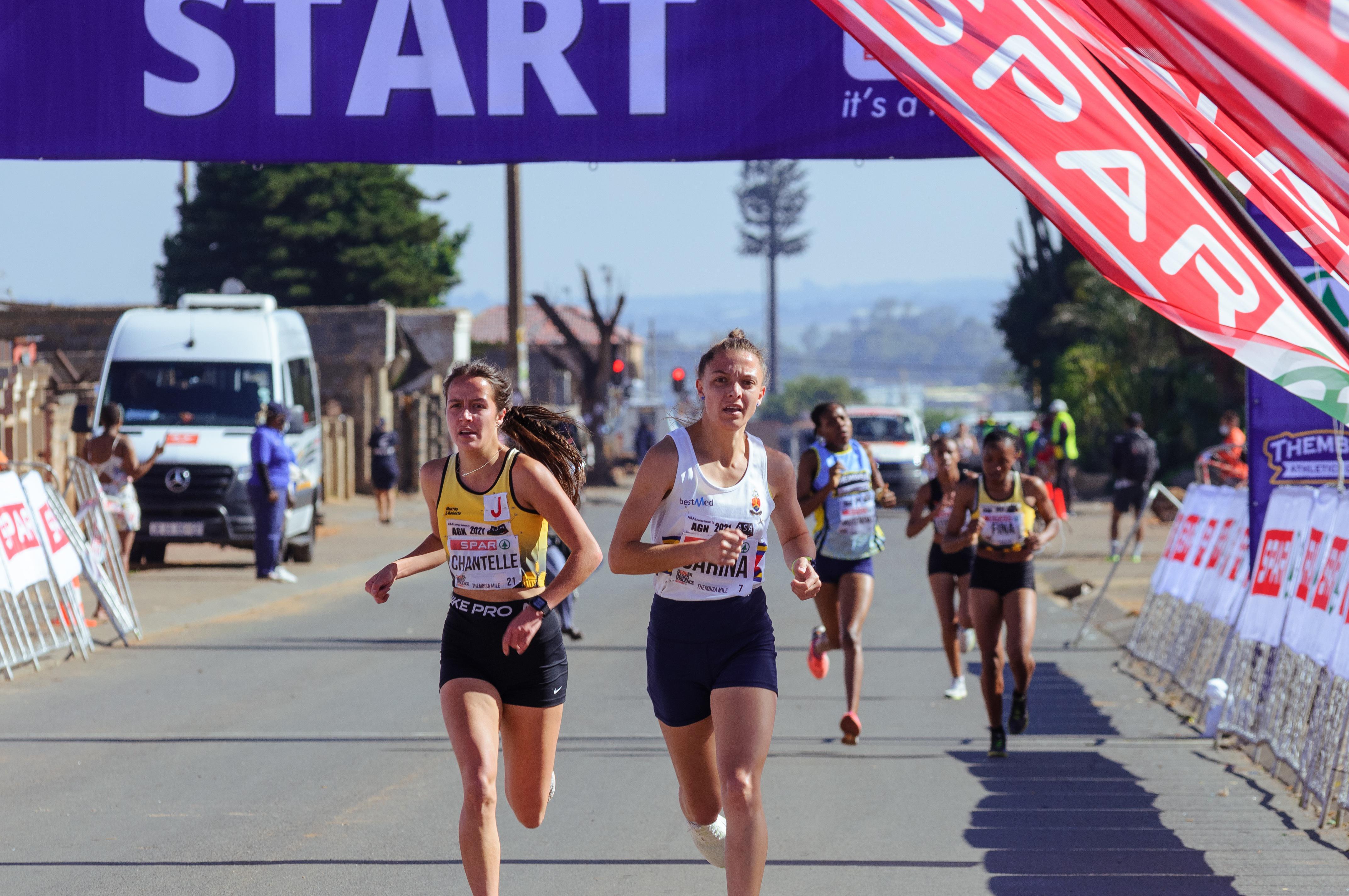 Zwei Läuferinnen laufen nach dem Einlauf ins Ziel auf die Kamera zu.