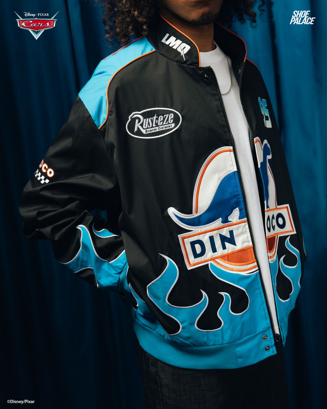 Person wearing a colorful jacket with a retro design against a blue background.