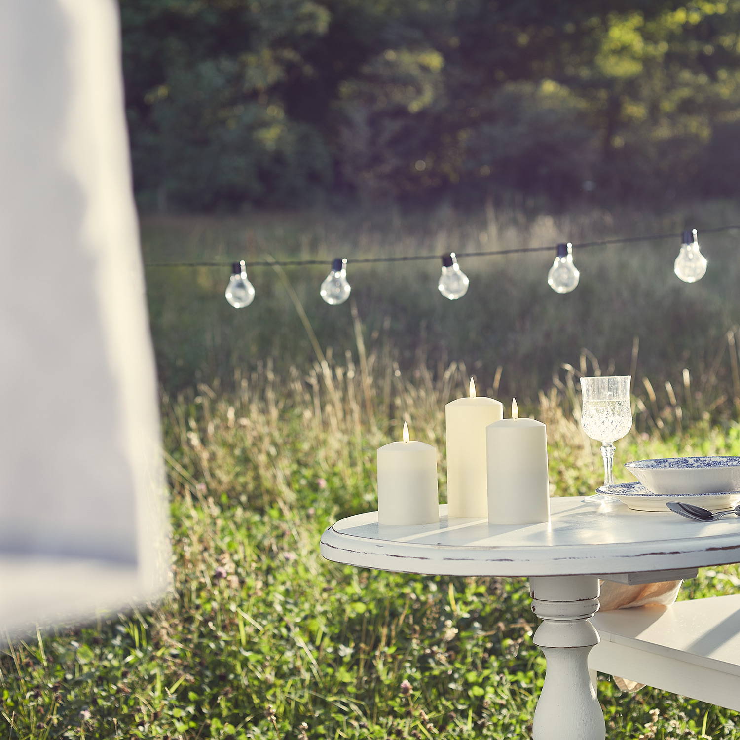 Small garden dining table with candles and festoons