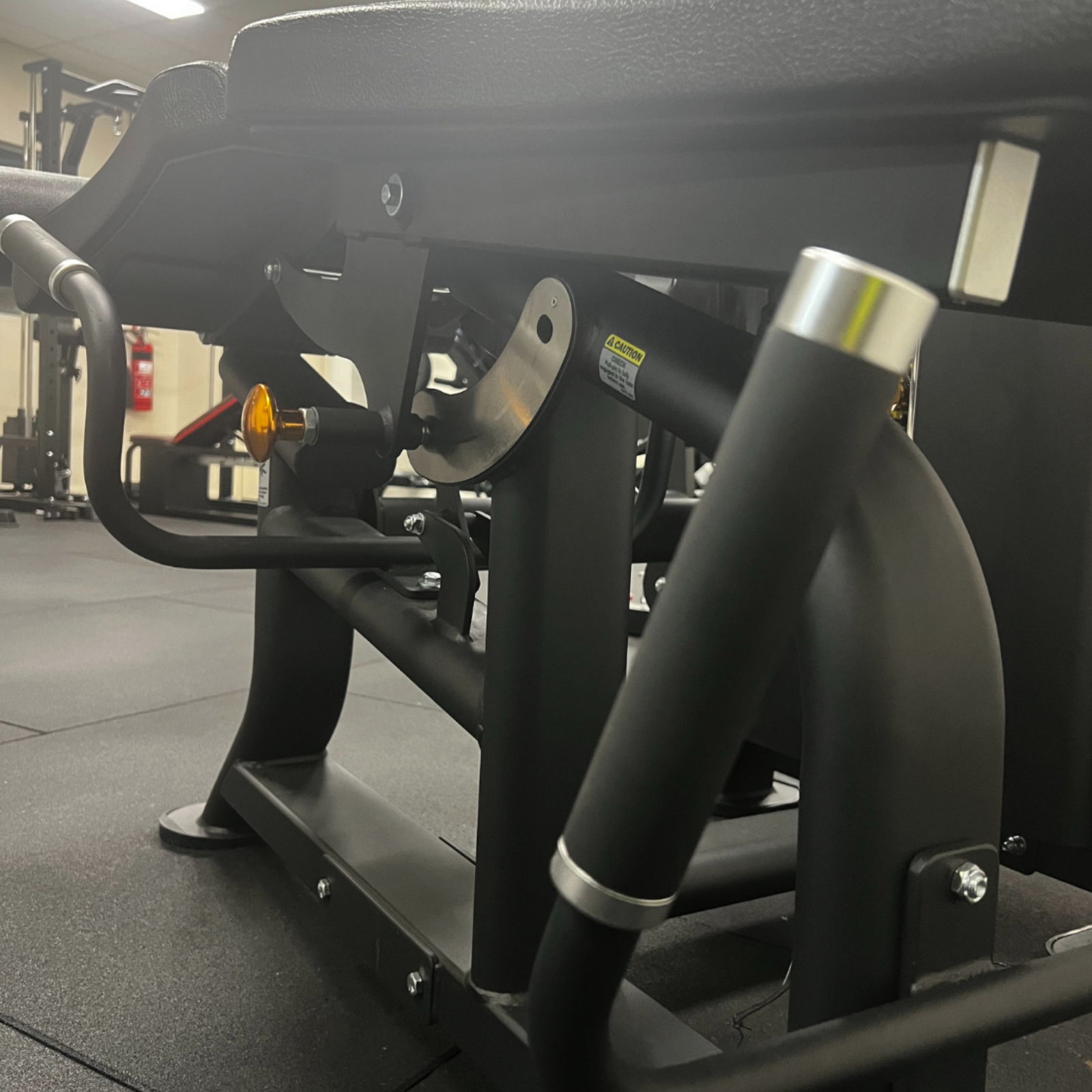 Close-up of gym equipment showing handles and frame structure.