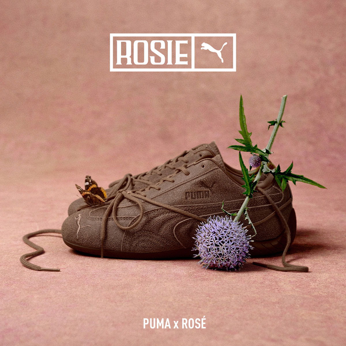 Brown Puma sneakers adorned with plants and flowers on a pink background.