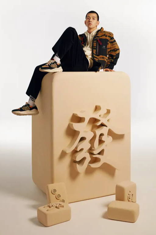 male model sitting on wood chinese symbol wearing new balance chinese new year apparel and shoes