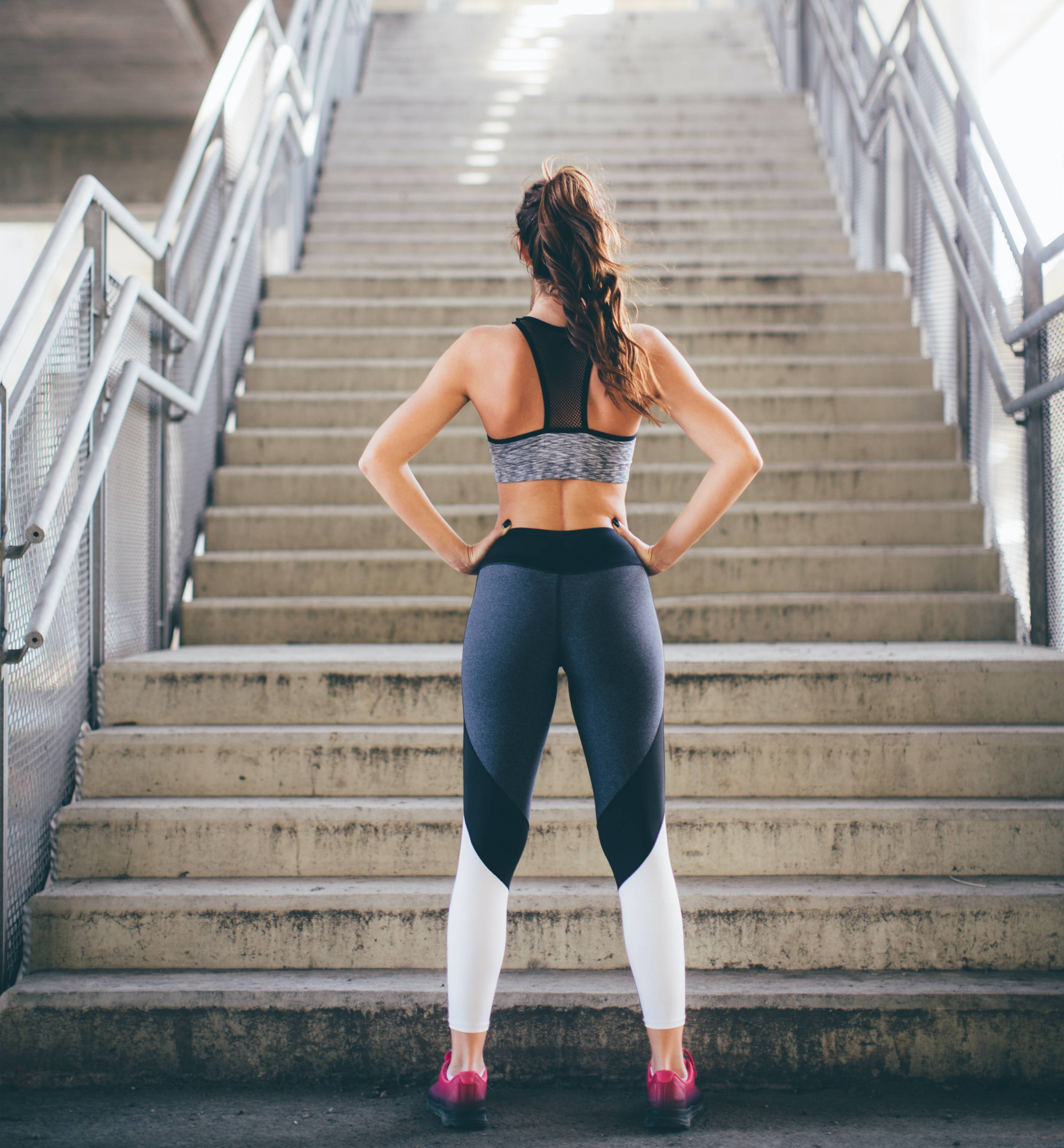 Active woman about to run up stairs after drinking Plantworks protein shake. 