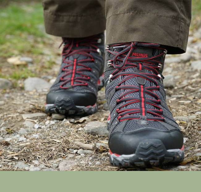 Meindl Mens Mid Boots being worn on a stone path.