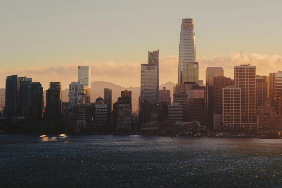 The San Francisco skyline at golden hour across the dark water of the bay
