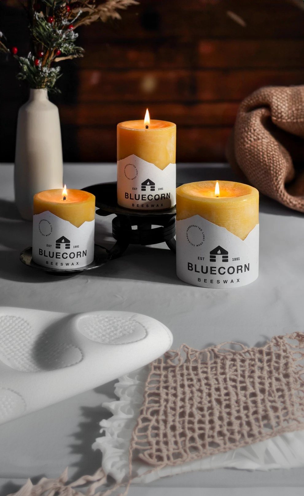 Three Bluecorn beeswax pillar candles on a stand