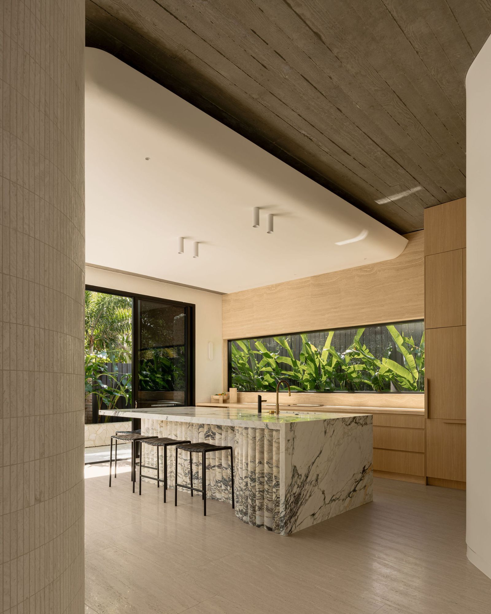 Modern minimal kitchen with ceiling lights above a stonework bench
