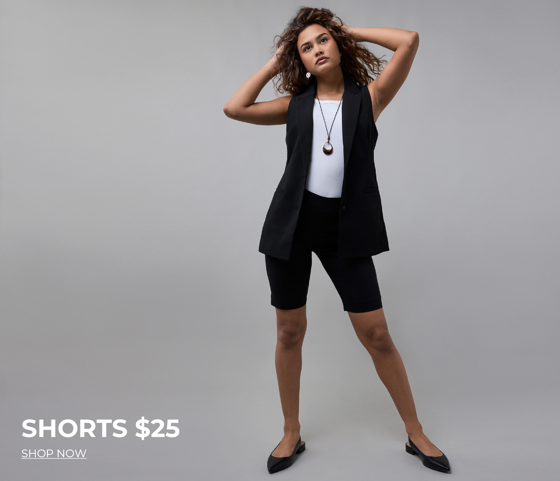 Model wearing a black outfit with shorts, showcasing a stylish pose.