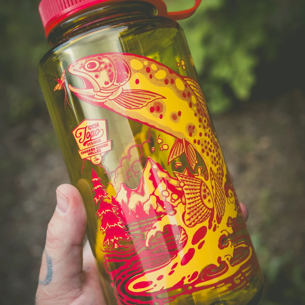 Colorful water bottle featuring a fish design and red cap.