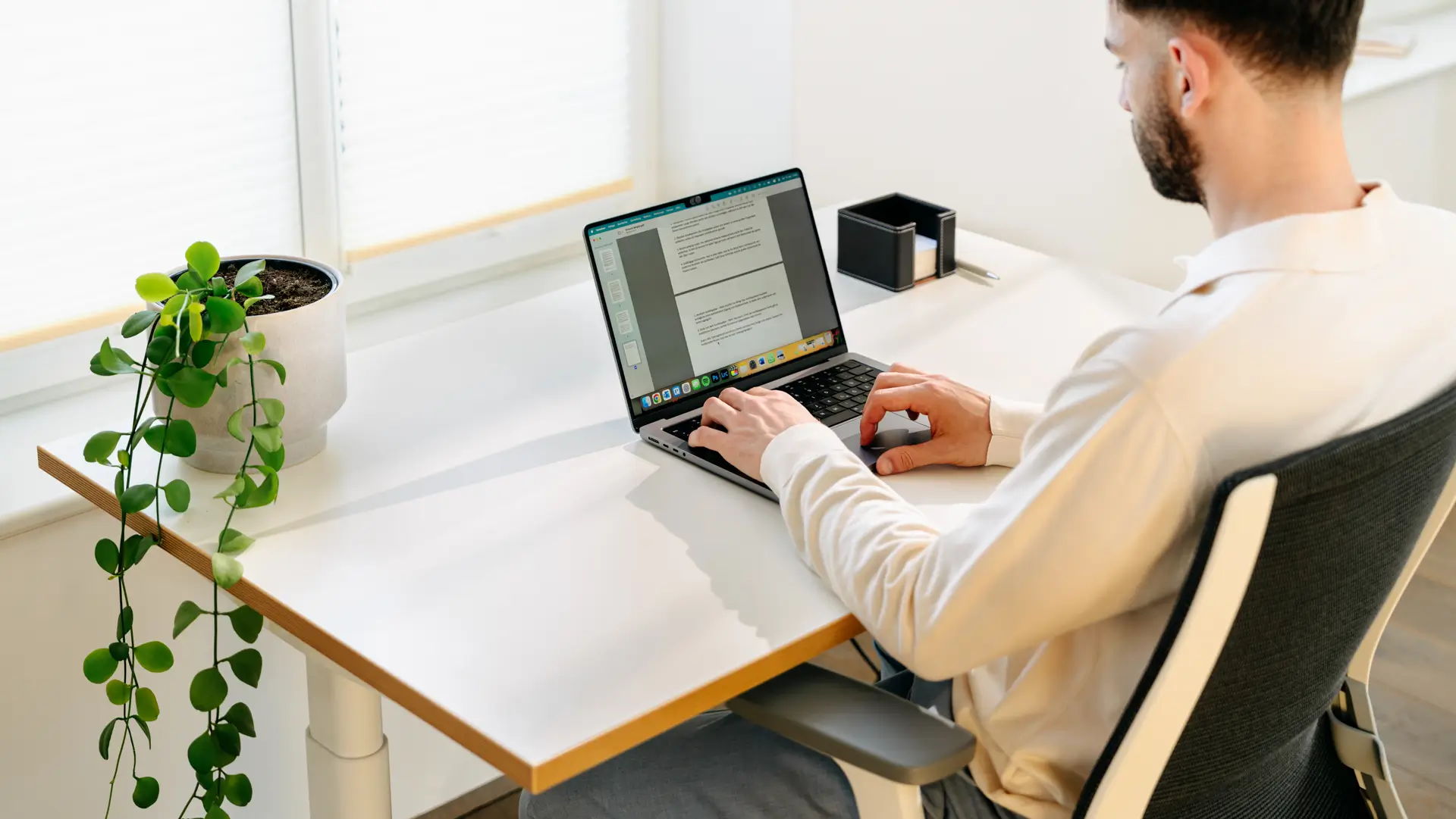 Un homme travaille sur un ordinateur portable posé sur un bureau Rise de ofinto