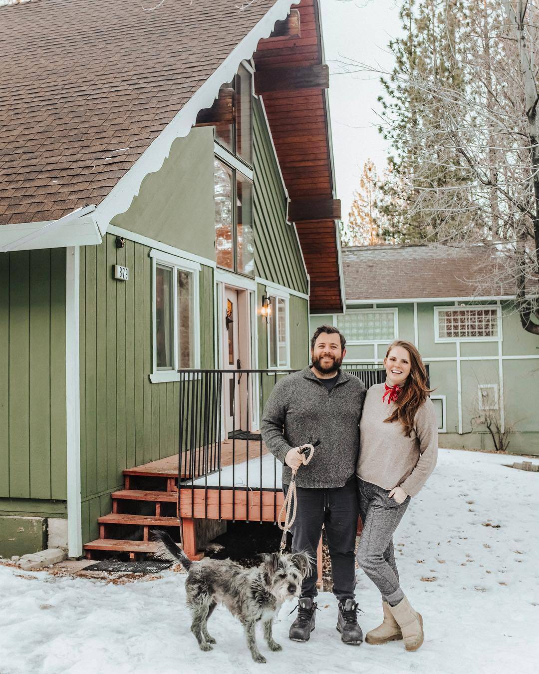 Blogger Claire Thomas poses with her husband and dog in front of their kitchy cabin where Boxhill helped design and furnish their outdoor space. 