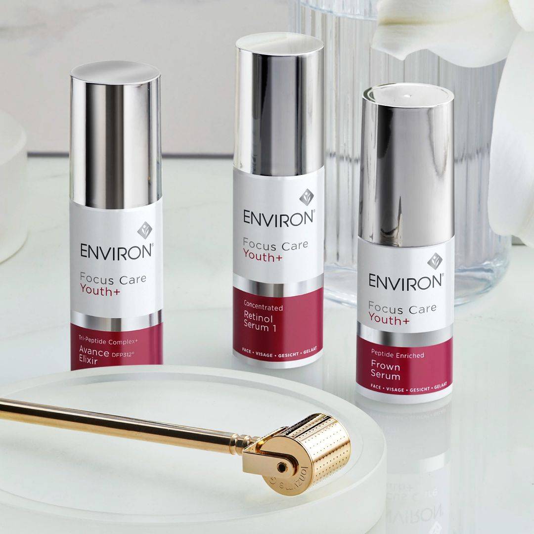 Three Environ products and a derma roller on a clear table. The products are Focus Care Youth+, Focus Care Youth+ Advance Elixir, Retinol Serum 1 and Frown Serum