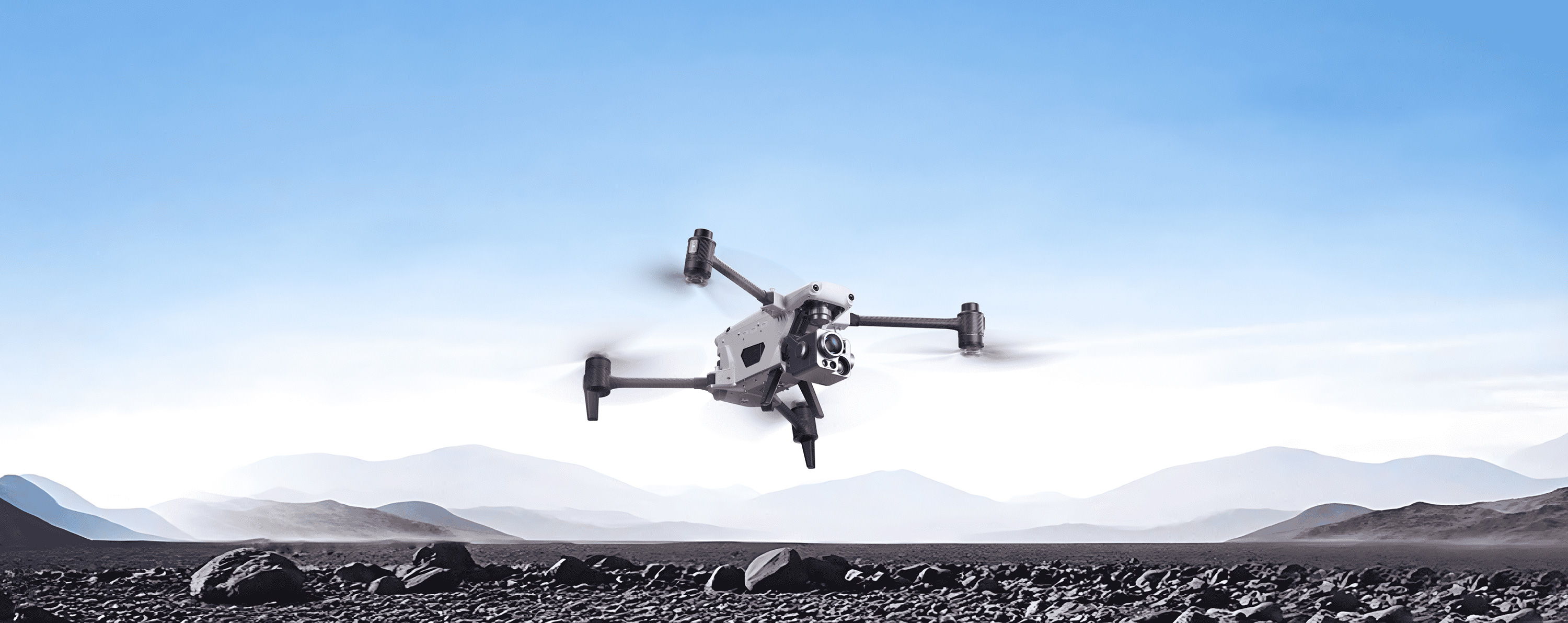An Autel Alpha drone flying over a rocky landscape under a clear blue sky.
