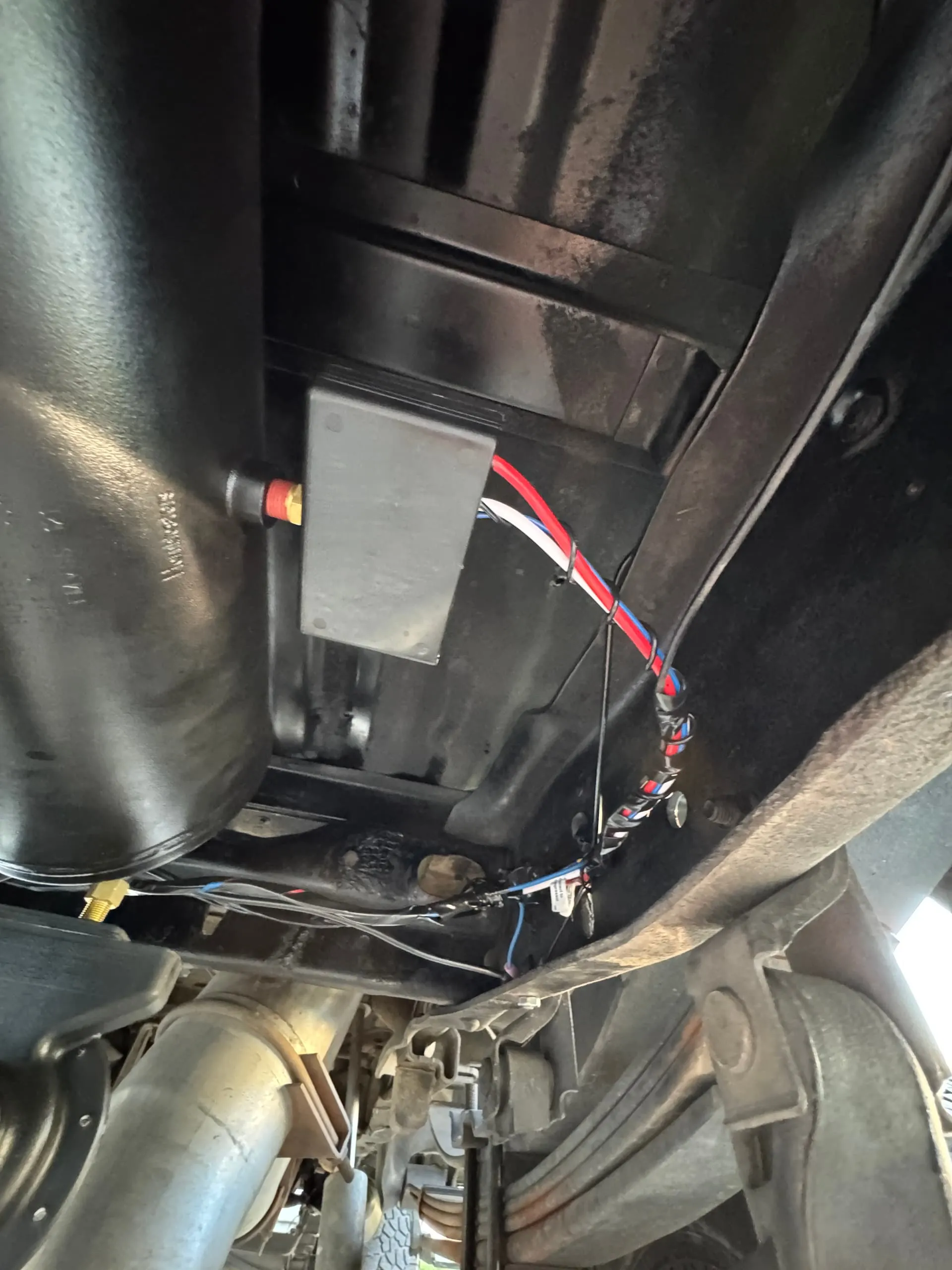 Air tank and control box with wiring installed on the undercarriage of Noah's Ford F250