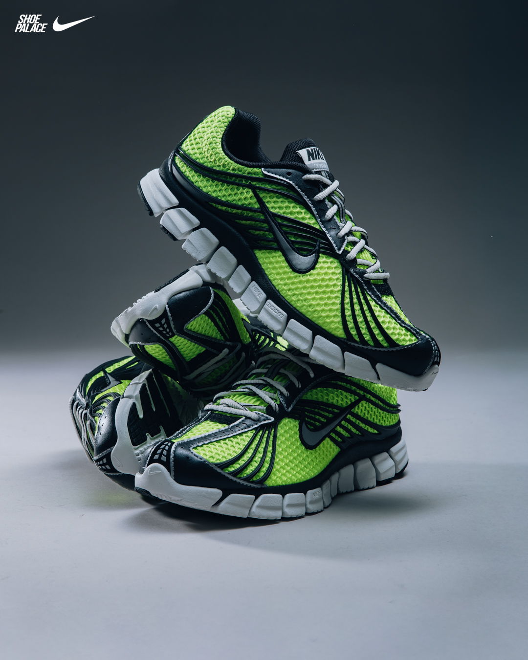 Nike shoes in vibrant green and black stacked on a gray background.