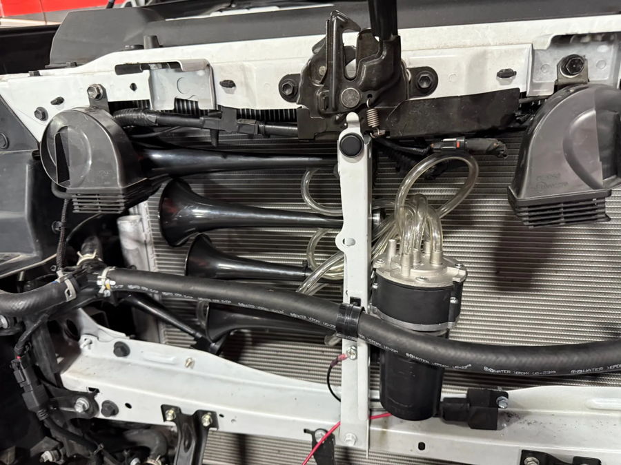 Engine bay four black train horns in front of radiator compressor clear air lines DENSO OEM horns Jay's 2024 Tundra 228H gallery photo 5