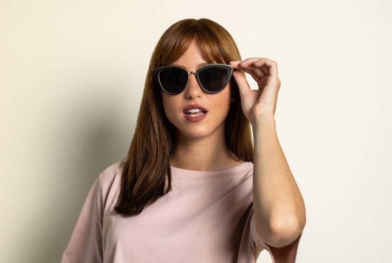 woman wearing Willow, oversized cat eye sunglasses, on a solid background