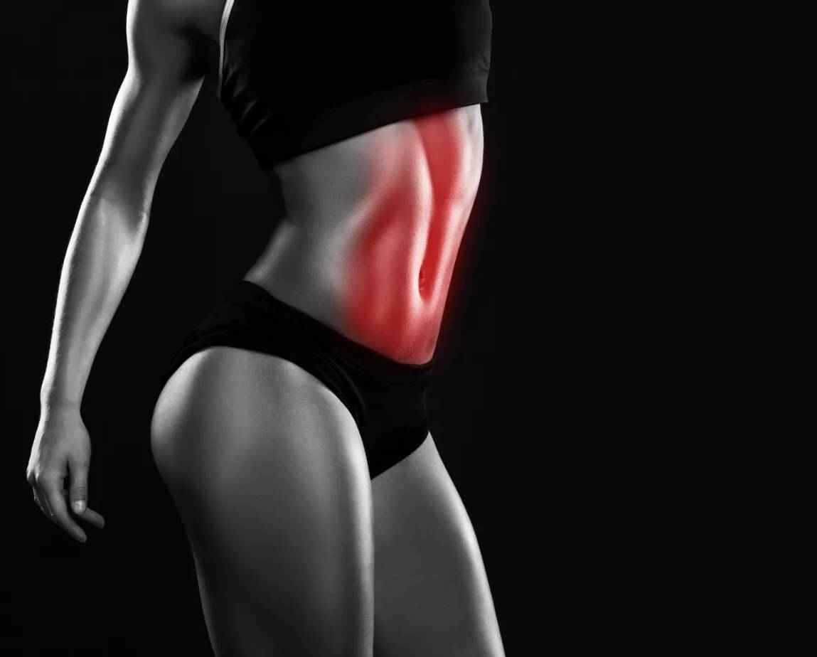 Una foto en blanco y negro de la sección media de una mujer con los músculos abdominales resaltados.