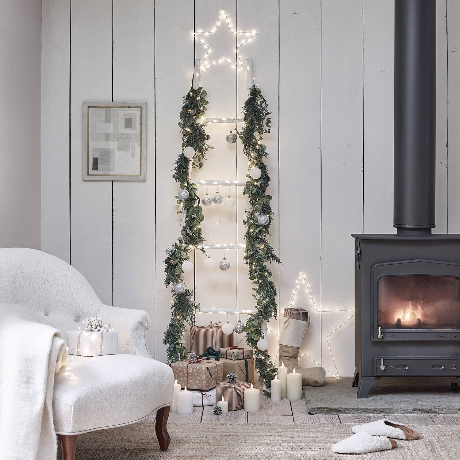 DIY ladder tree decoration adorned with LED lit garlands, white and silver baubles, and topped with a warm white LED star light