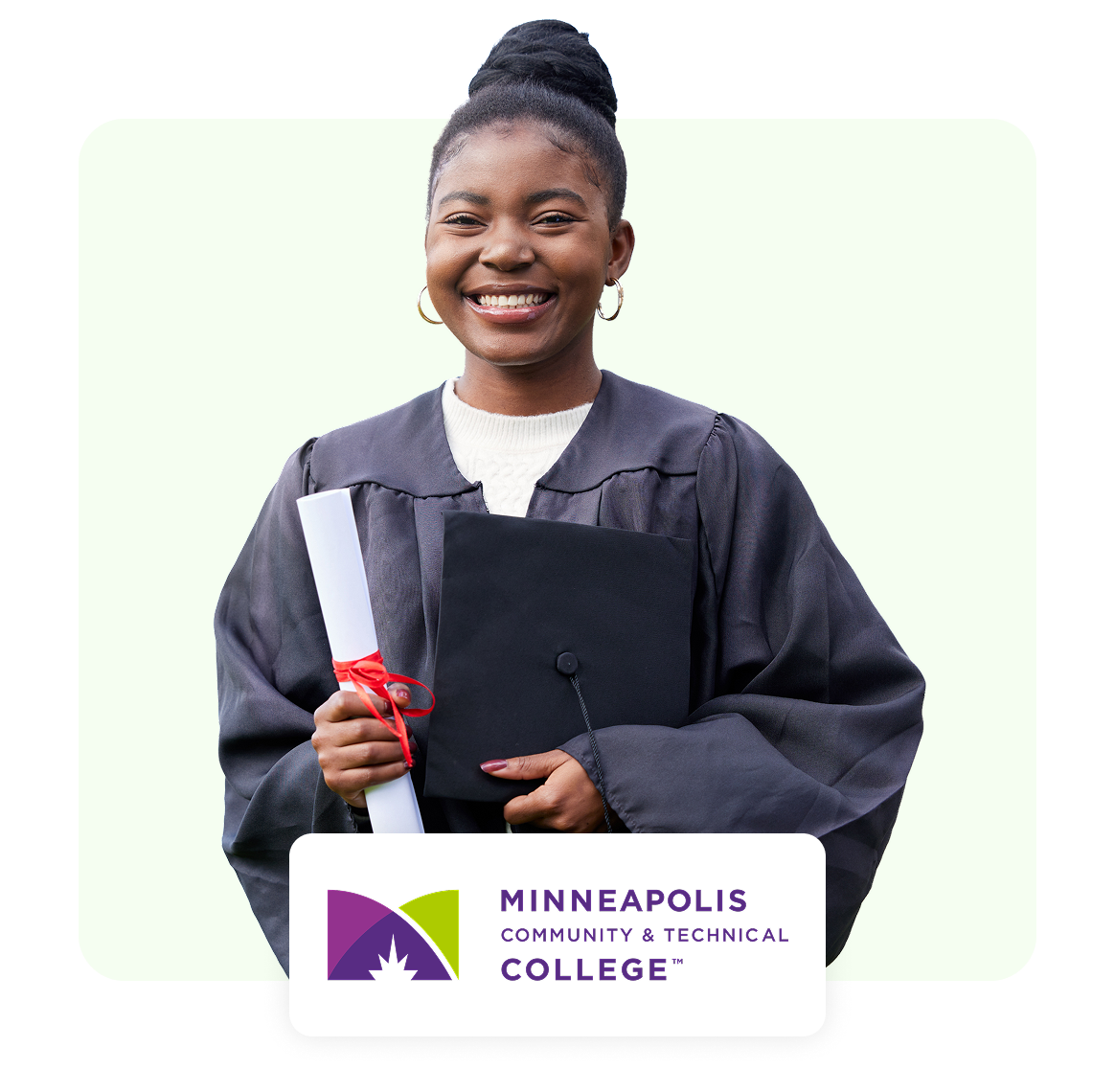 Smiling graduate holding diploma and binder, wearing cap and gown.