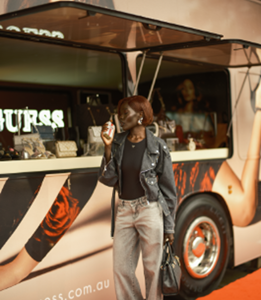 A person standing in front of a stylish food truck.