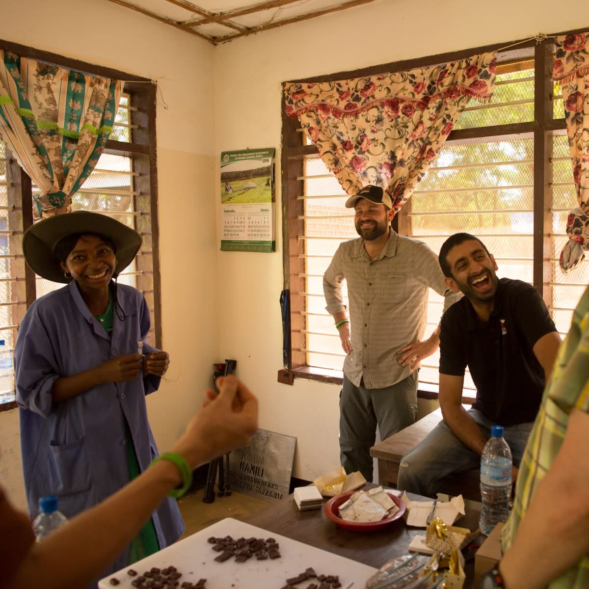Group of people interacting in a room with natural light and decorations.