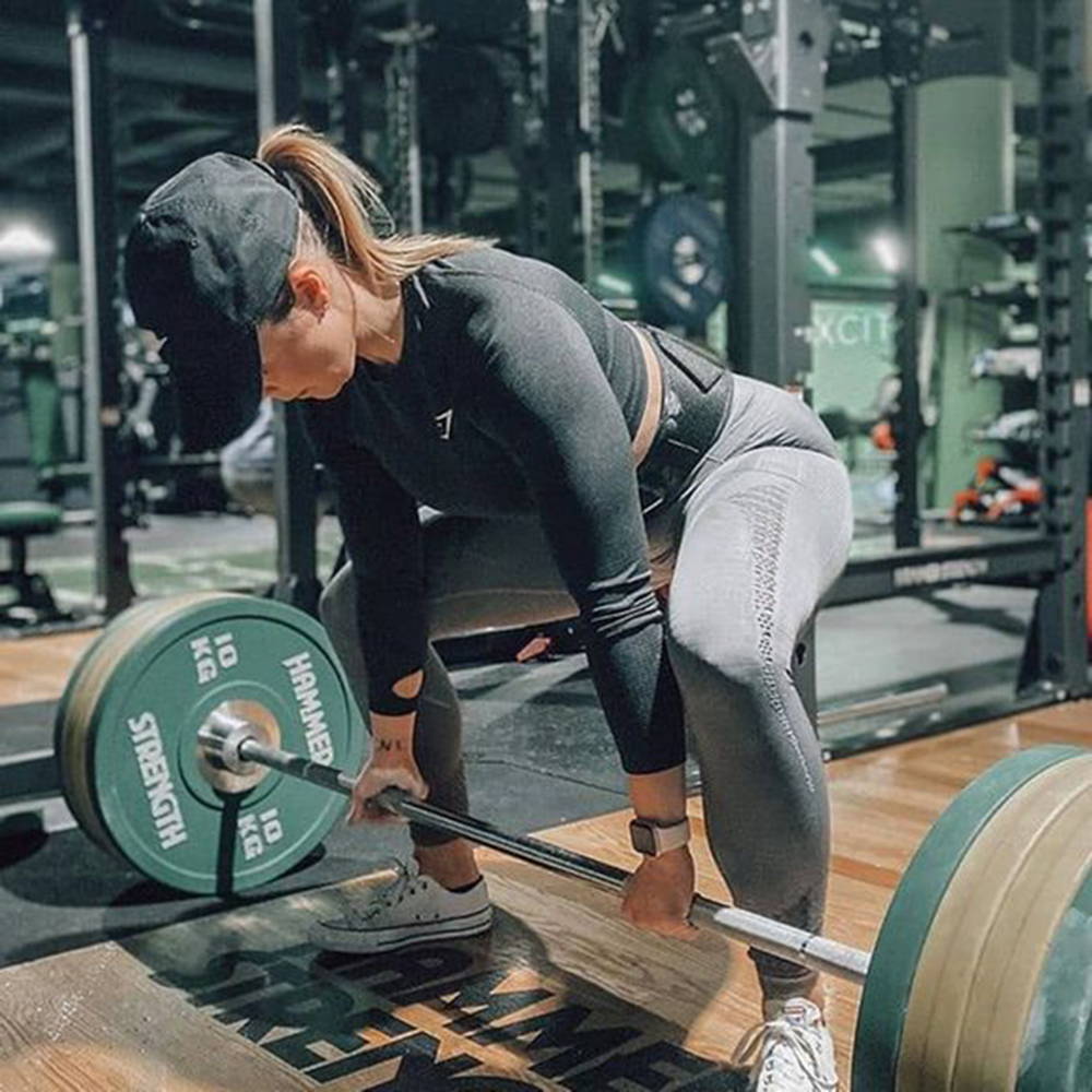 Female at gym deadlifting with Hammer Strength plates