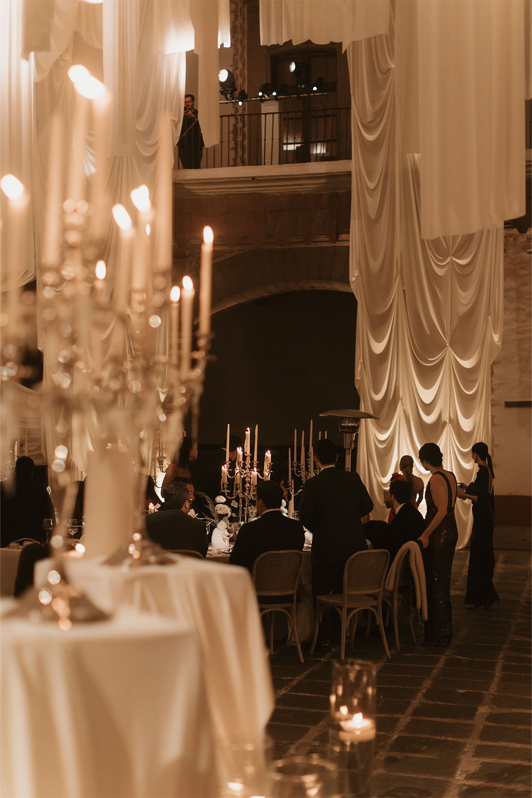 Extravagant wedding reception set up with candles and draped curtains 