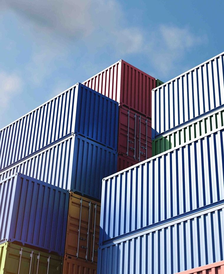 Colorful shipping containers stacked against a blue sky.