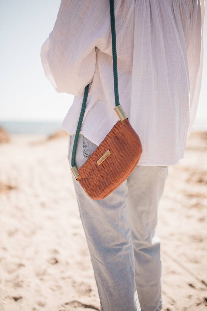 woman wearing brown basketweave leather oyster shell bag
