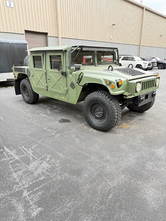 Front-three-quarter view Greg's matte olive drab 2008 AM General HMMWV Humvee with roll cage LED light bar and Goodyear Wrangler off-road tires HornBlasters Outlaw Train Horn featured install gallery photo 1