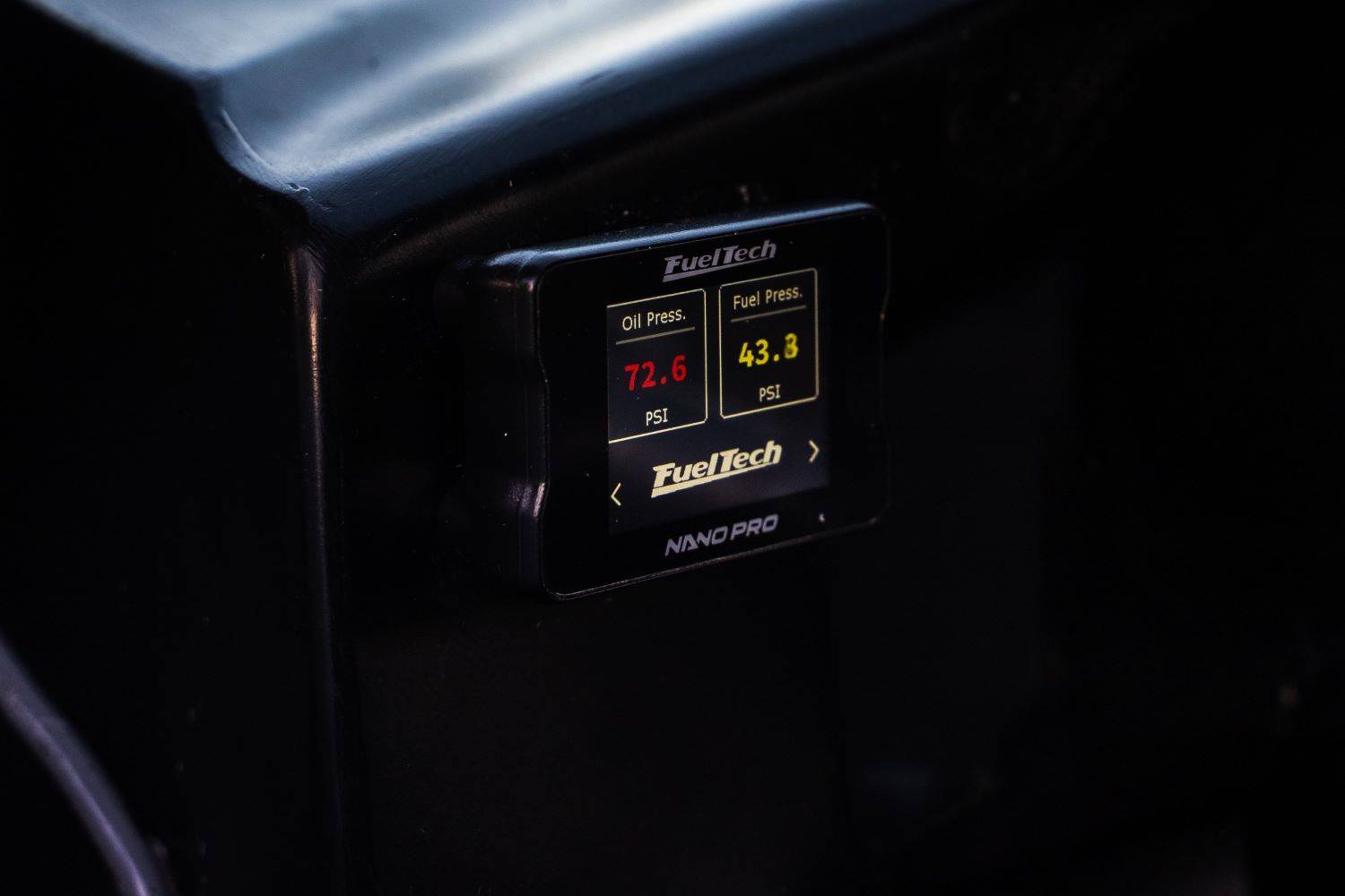 FuelTech's NanoPRO O2 Conditioner with color touchscreen, gauge display, and virtual switch panel as installed in cockpit of racecar. 