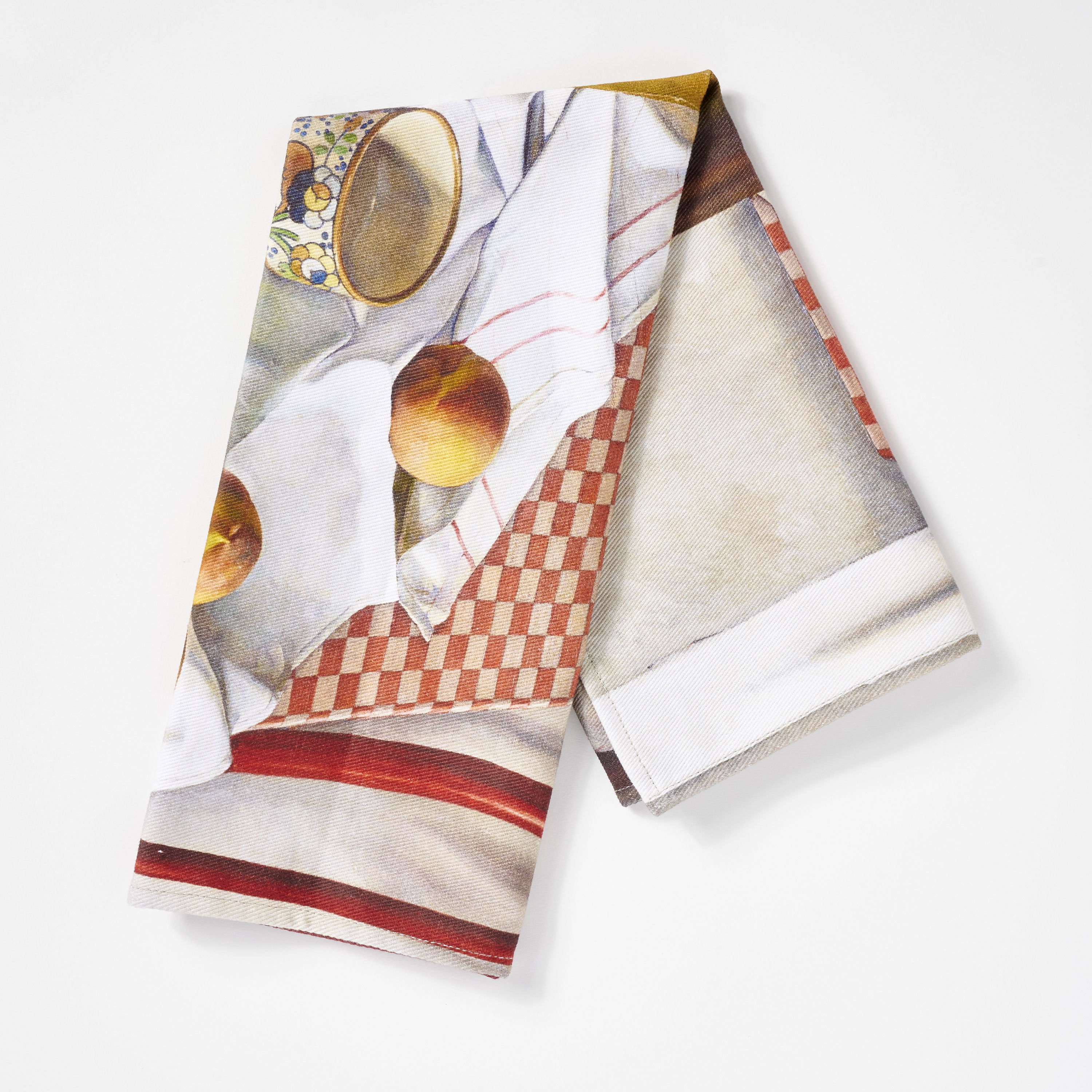 A folded kitchen towel with a colorful design and fruit.