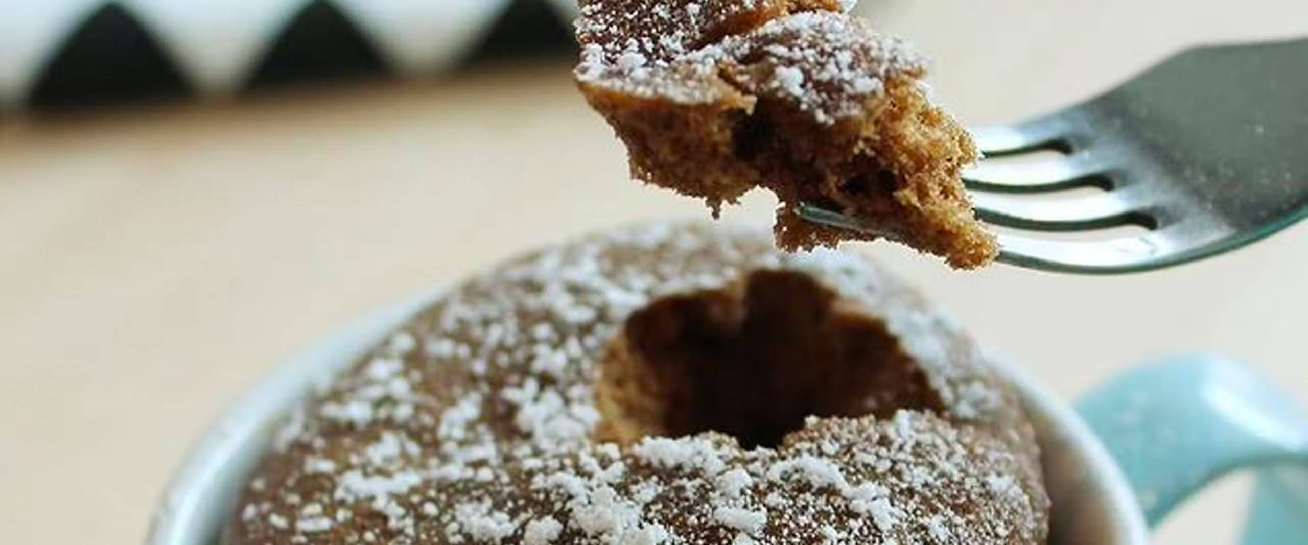 Close up of a fork with Microwave-Style Chocolate Souffle out of a mug.