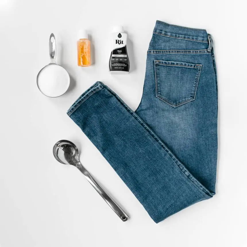 A pair of jeans with various household items arranged around it.