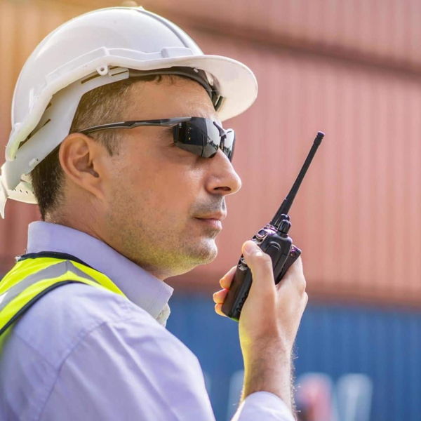 Trabajador de logística utilizando un radio de comunicación