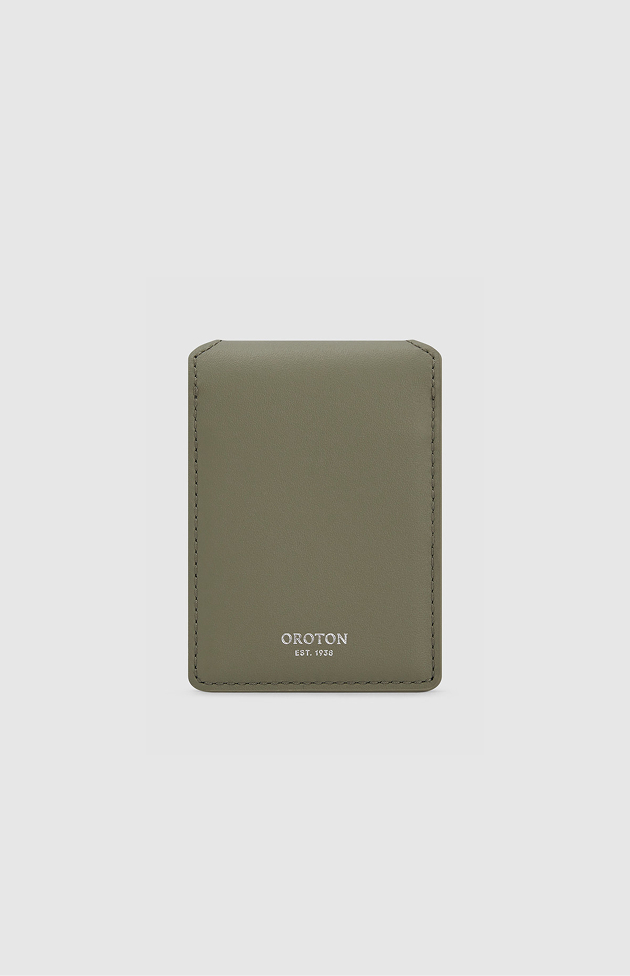Green cardholder with embossed logo on a light gray background.