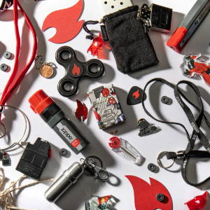 Lifestyle image of Zippo I Spy 540 Color Windproof Lighter, laying within a handful of Zippo themed items.