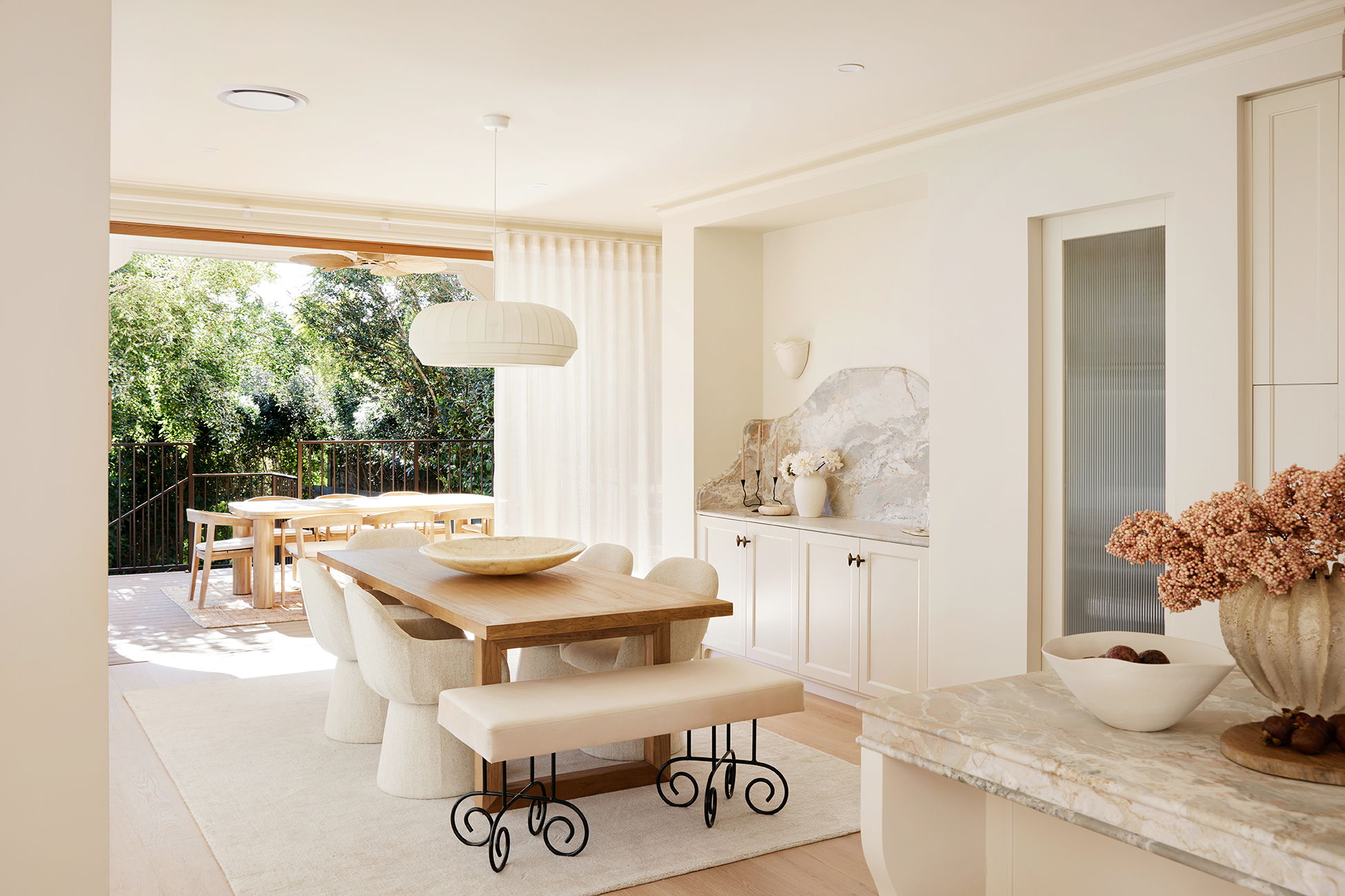 Modern dining area with wooden table, bench, and natural light.