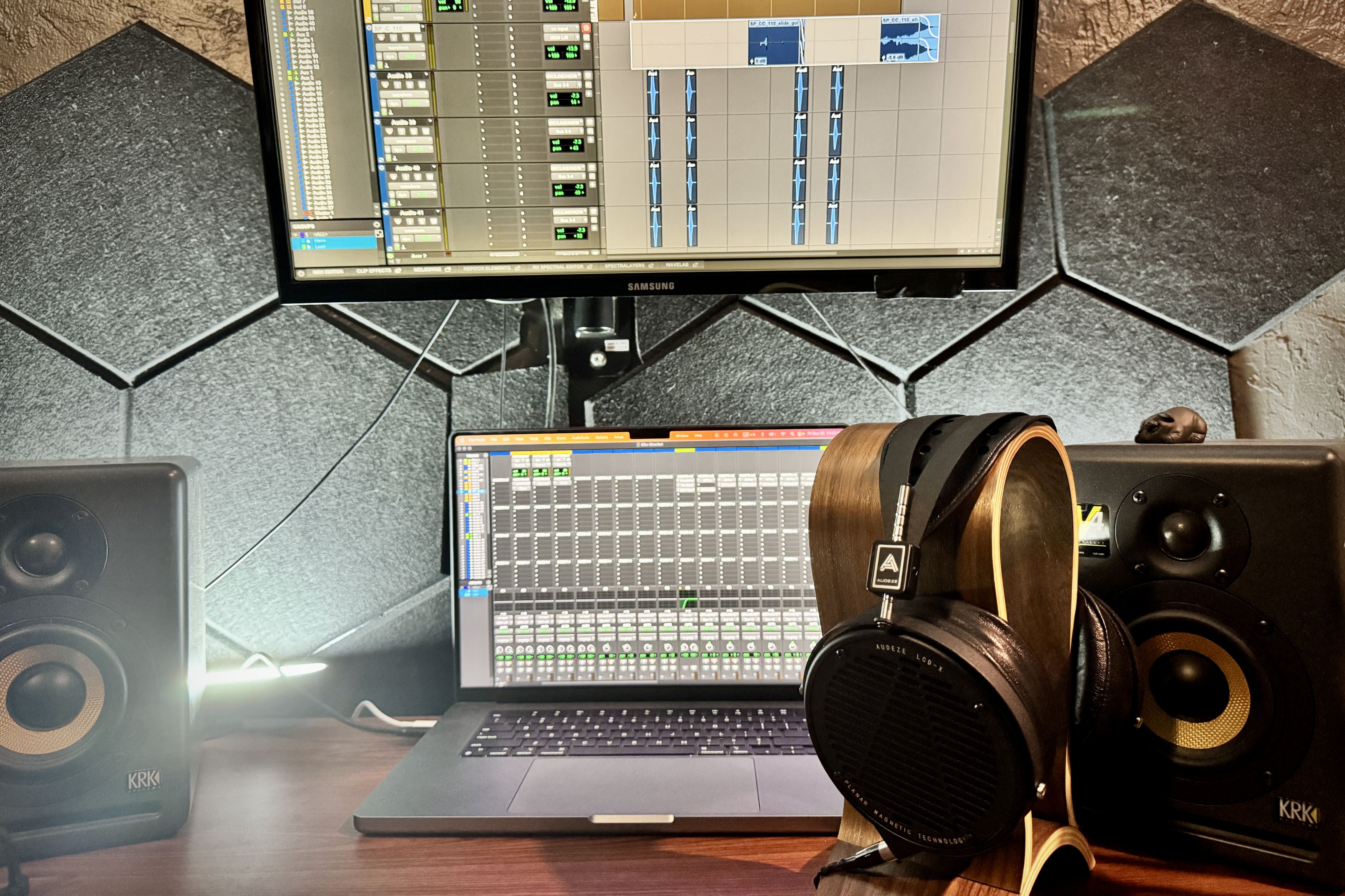Audeze LCD-X headphones on a headphone stand in front of a studio setup