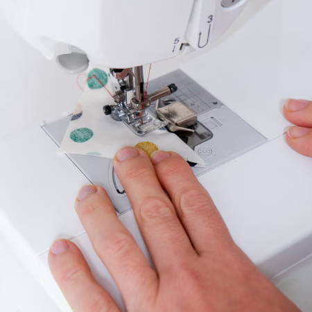 Piecing for a quilt with a magnetic seam guide on a sewing machine