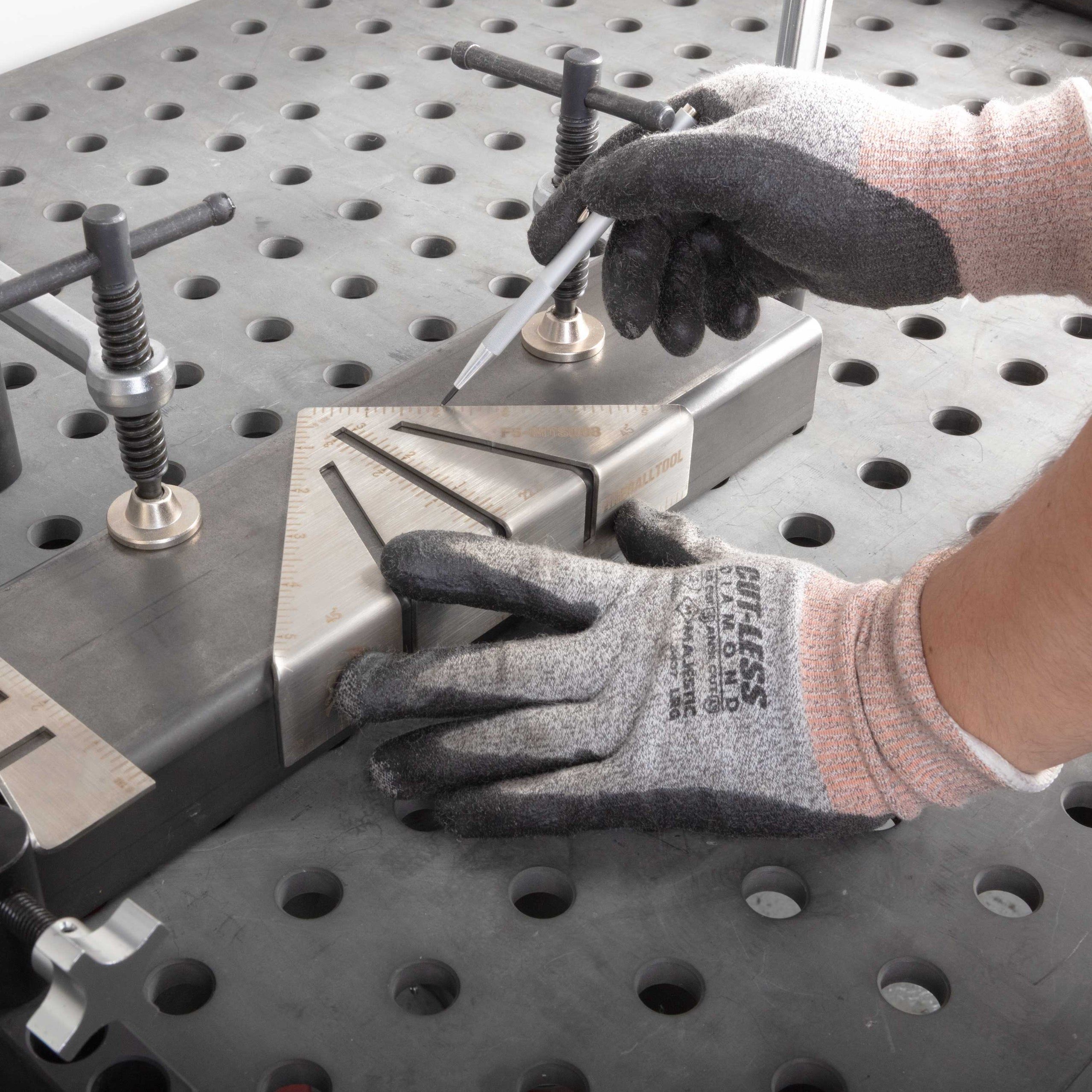 A person using tools on a metal workbench with clamps and a measuring tool.