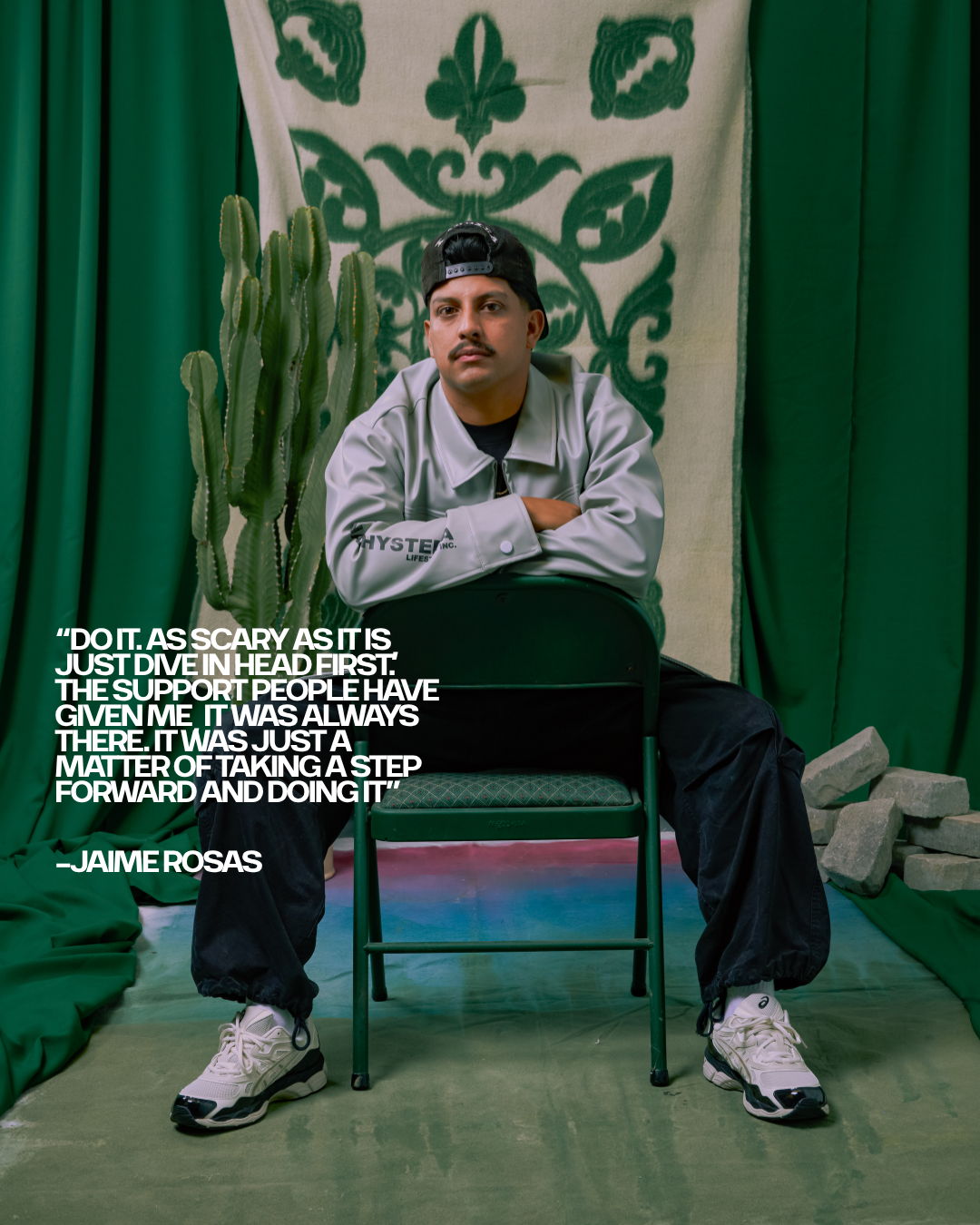 Person seated on a chair with green backdrop and inspirational quote.