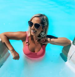 Woman wearing Willow, wooden cat-eye trendy glasses with a pink bathing suit