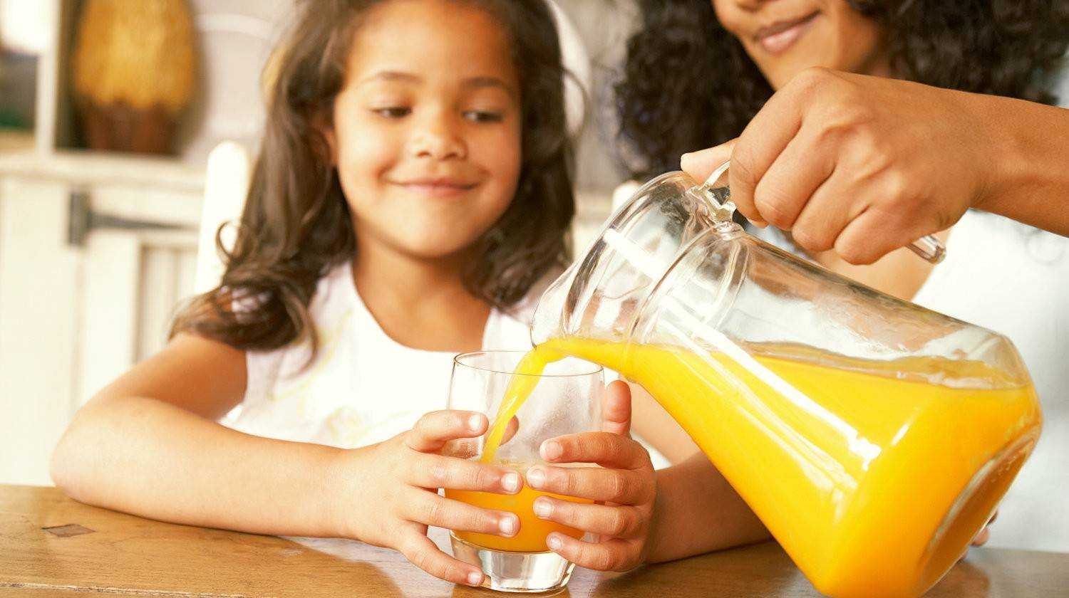 Featured | Mother pouring fresh orange juice from a jug  | Natural Vitamin C vs Synthetic Vitamin C: What's The Difference?