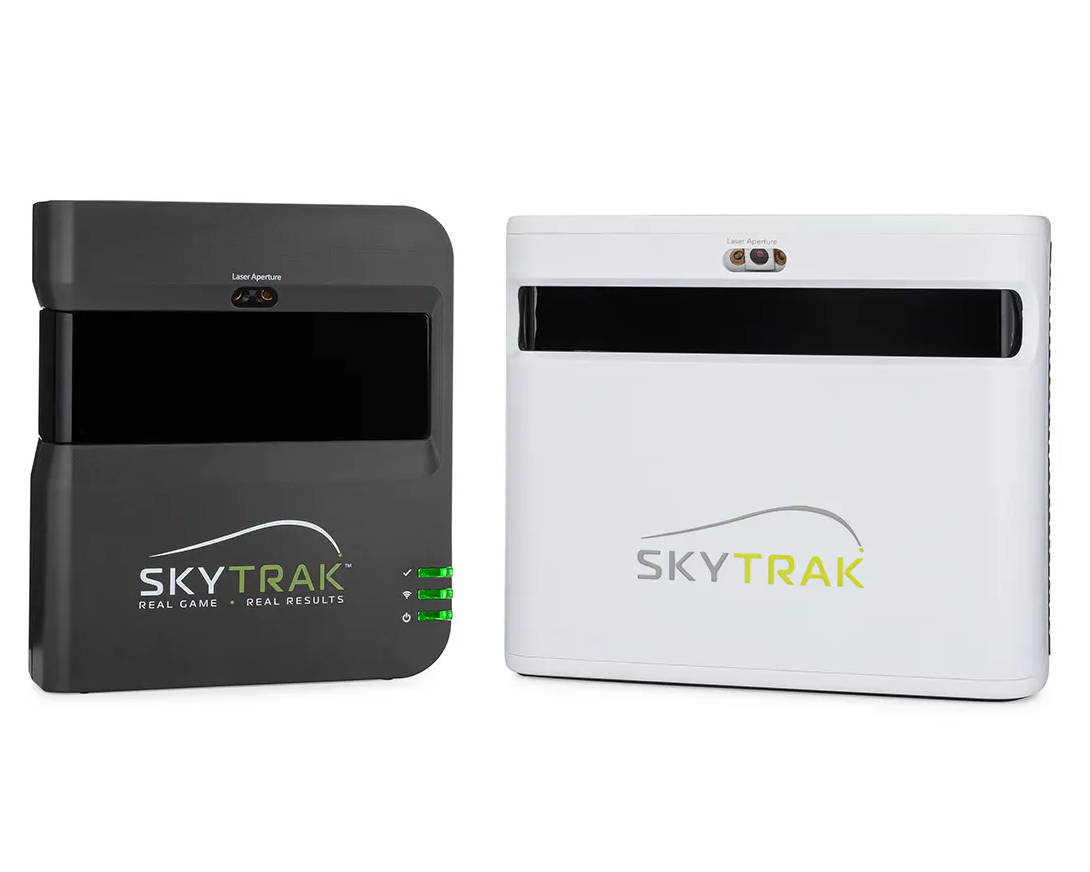 The dark gray SkyTrak golf launch monitor and simulator next to the new white SkyTrak+ unit