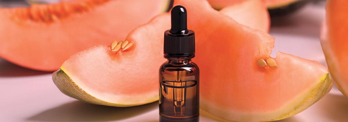 Brown dropper bottle in front of sliced cantaloupe.