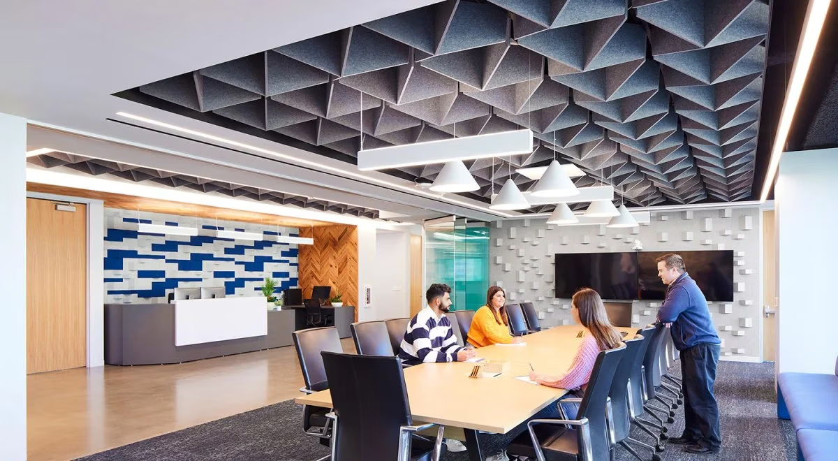 Modern office conference room with people around a large table.